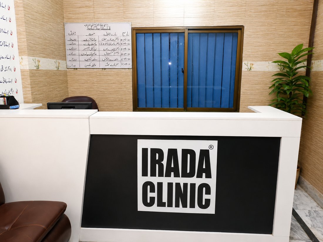 The reception desk at IRADA's Islamabad clinic, branded with the IRADA Clinic sign.